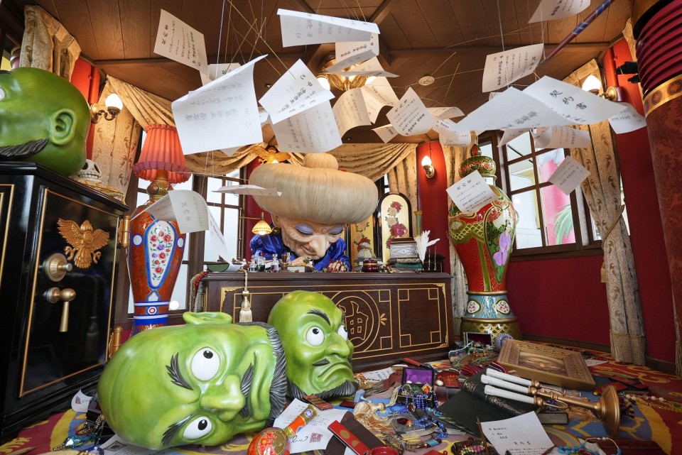 Ghibli Park photo of "Spirited Away" diorama featuring Yubaba filling out flying paperwork.