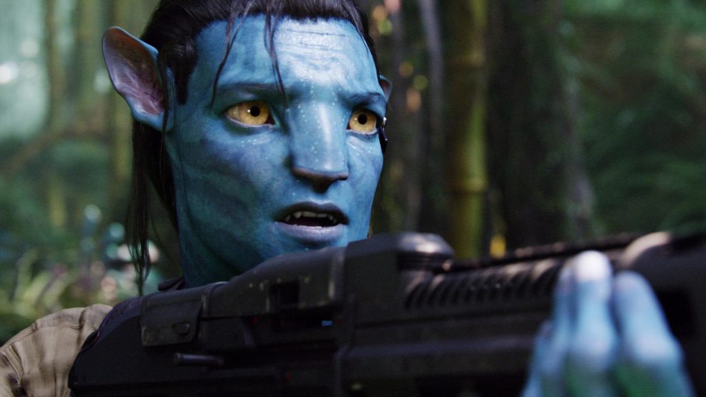 "Avatar" screenshot showing Jake Sully in his Na'vi body aiming a machine gun.