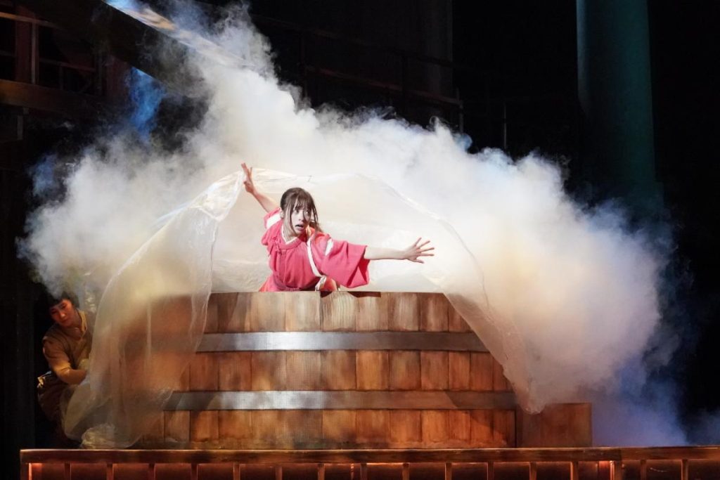 'Spirited Away: Live on Stage' photo of Chihiro pouring a lot more hot water into the bathtub than she should.