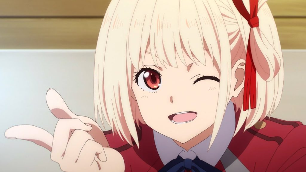 'Lycoris Recoil' anime screenshot showing Chisato with an impish look and a confident finger gun.