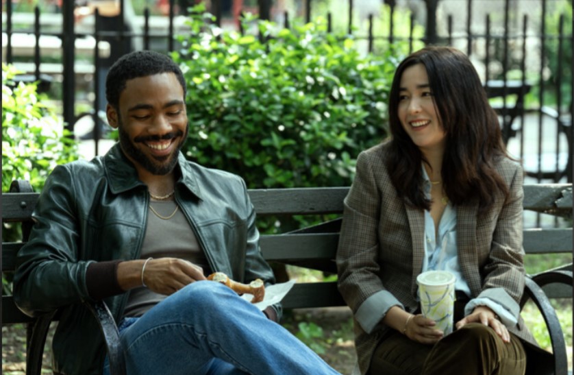 Donald Glover and Maya Erskine as John and Jane Smith, seated on a park bench